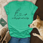Green t-shirt with "we the people and our dogs" text, feather, and paw prints.