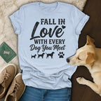 Light blue t-shirt with "Fall in Love With Every Dog You Meet" text and dog silhouettes.