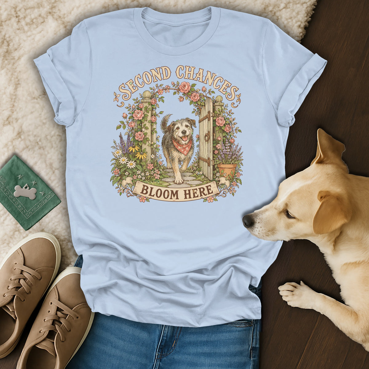 Light blue t-shirt featuring a dog graphic, surrounded by sneakers and a sleeping dog.