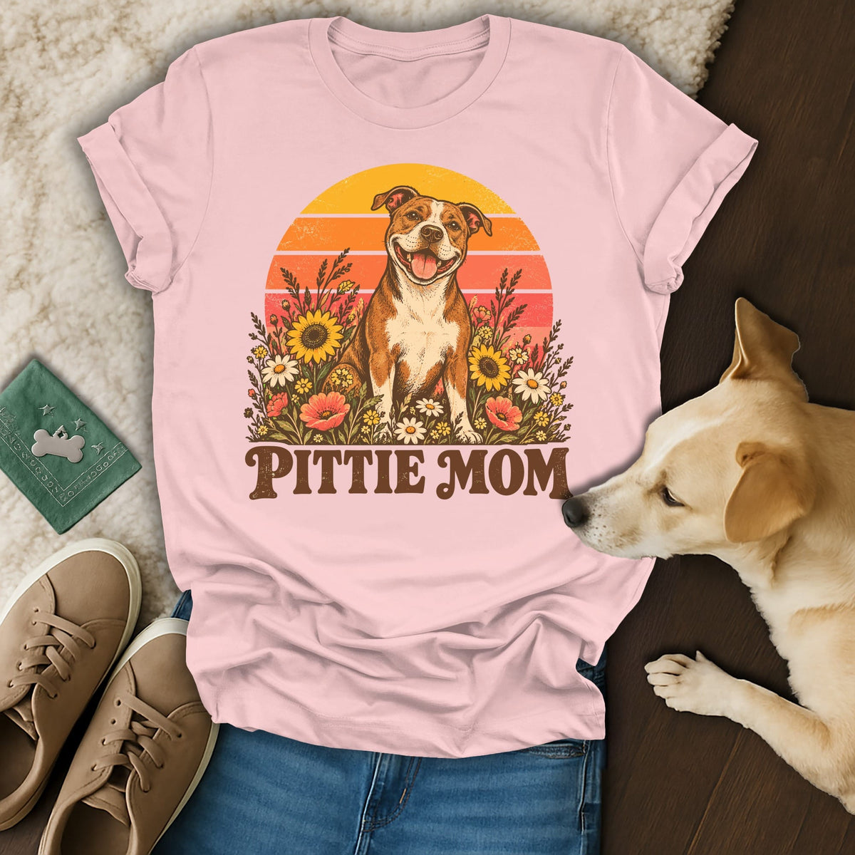 Light pink t-shirt featuring a retro graphic of a pit bull surrounded by flowers with the text Pittie Mom.
