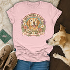 A light pink t-shirt with a vintage dog illustration and text reading Grey Muzzle Club.