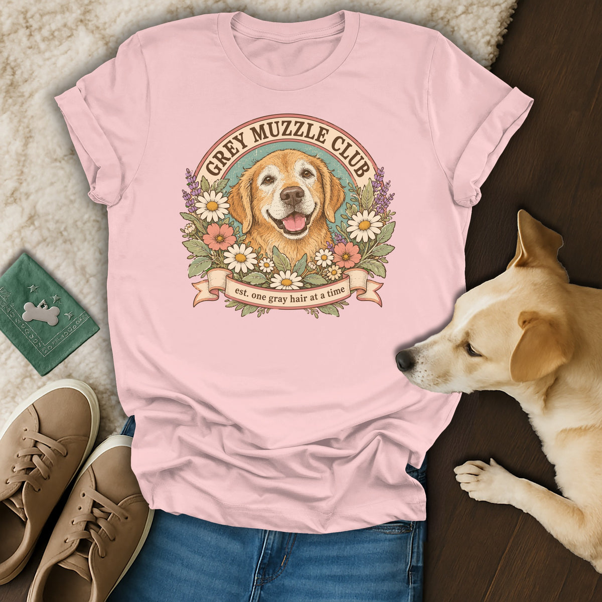 A light pink t-shirt with a vintage dog illustration and text reading Grey Muzzle Club.