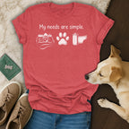 Red t-shirt with "My needs are simple" text, camera, paw print, and film roll graphics.