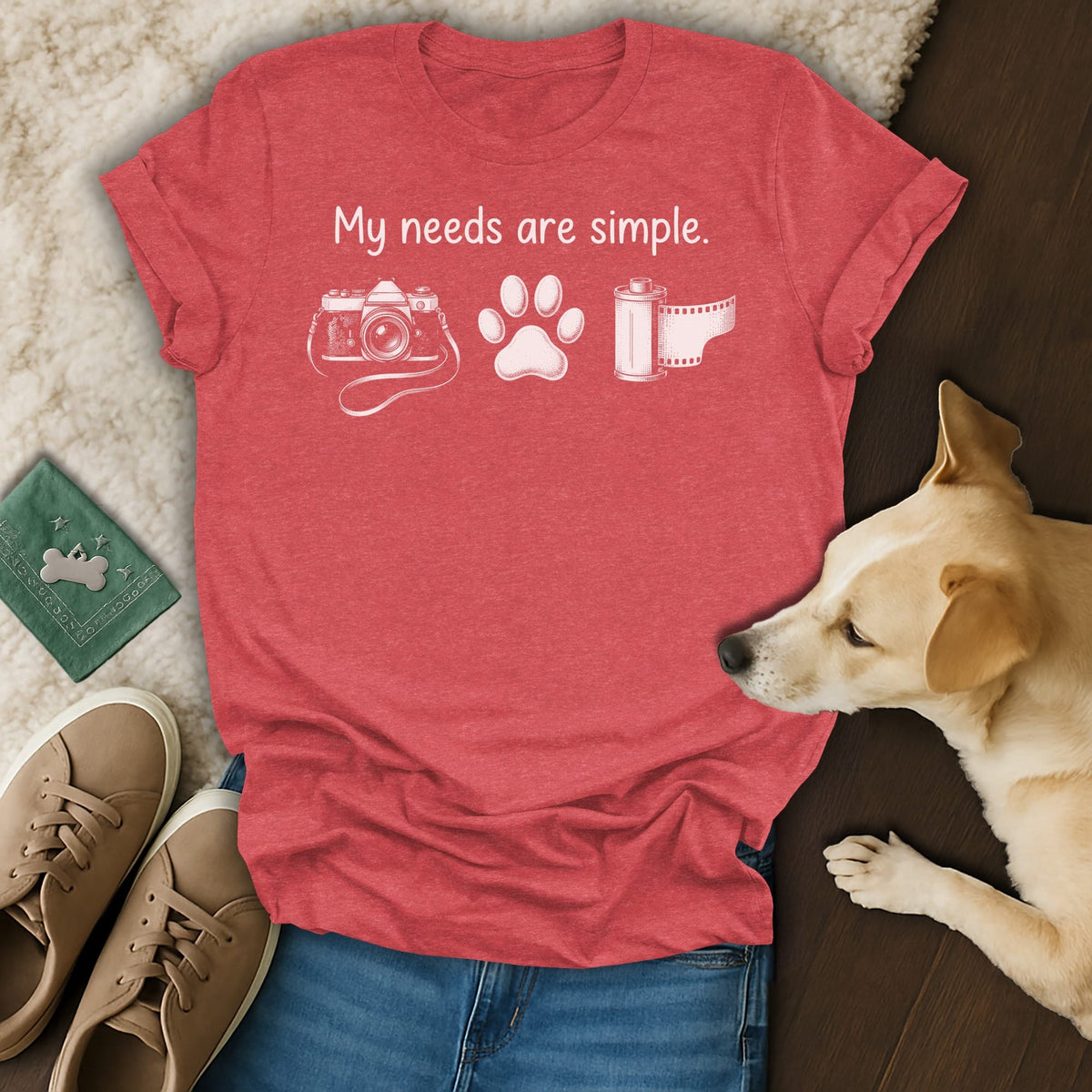 Red t-shirt with "My needs are simple" text, camera, paw print, and film roll graphics.