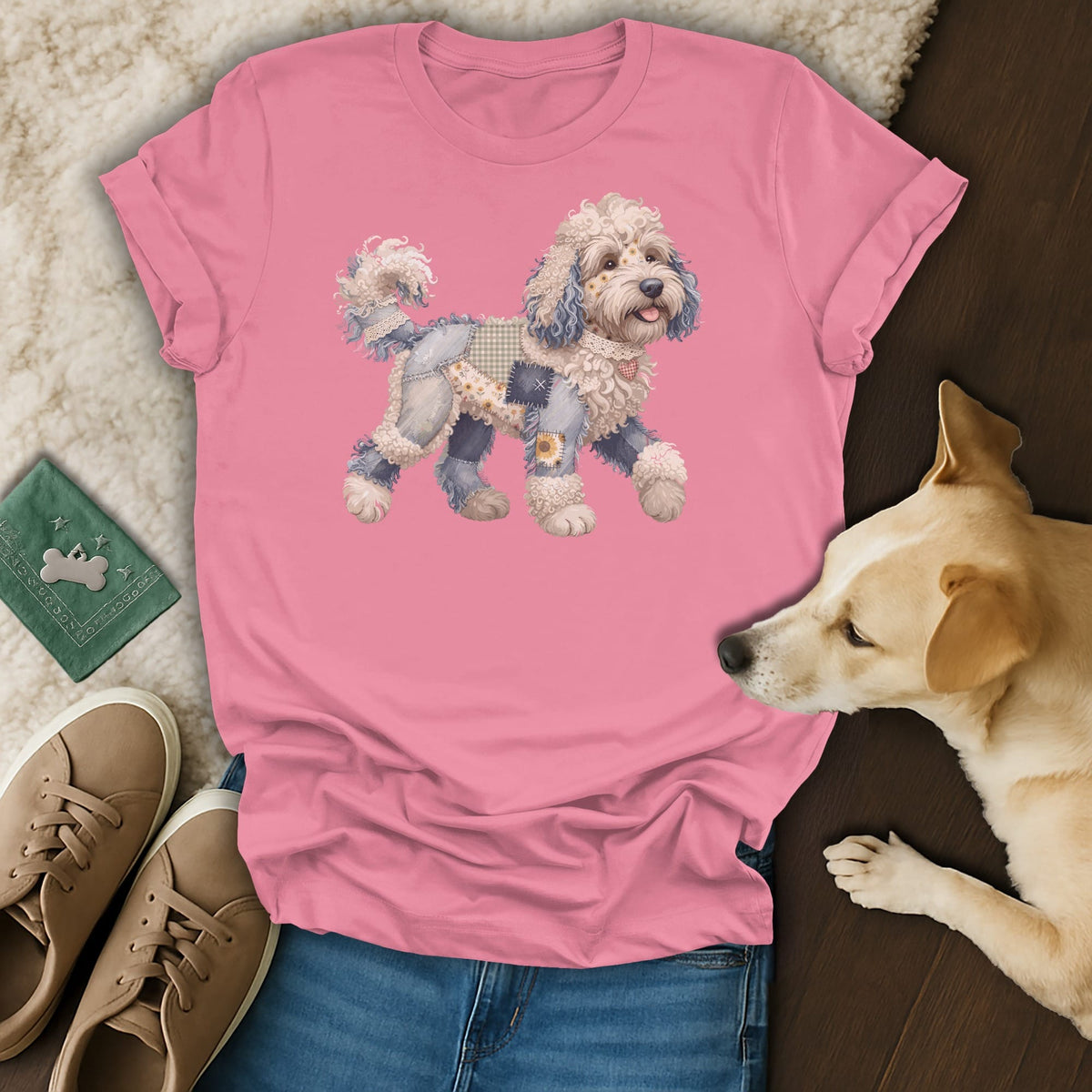 Pink t-shirt with a patched doodle dog graphic, next to jeans and sneakers.