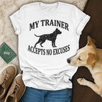 White t-shirt with black dog silhouette and text "MY TRAINER ACCEPTS NO EXCUSES."