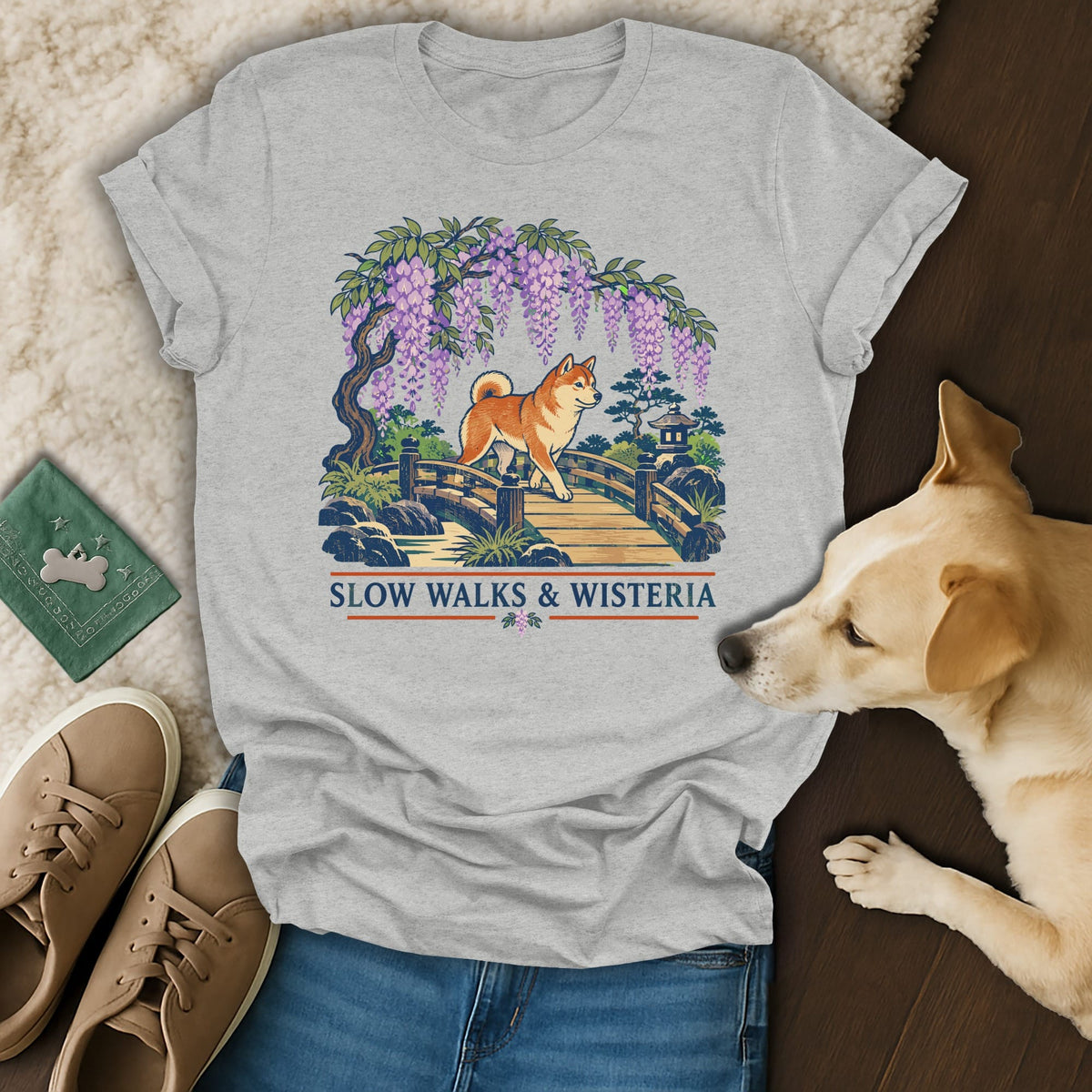 A heather gray t-shirt with a graphic of a Shiba Inu crossing a bridge under wisteria.