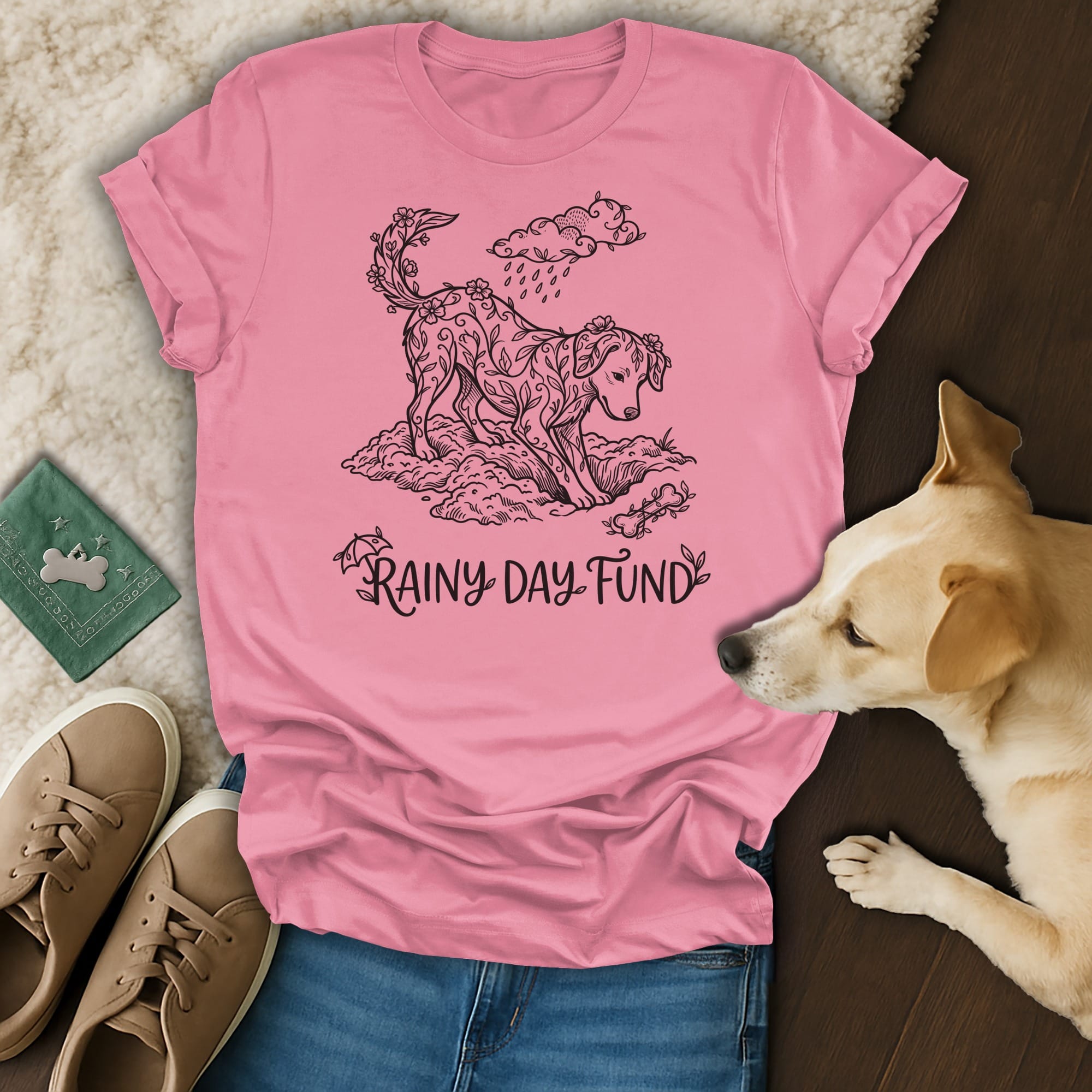 Pink t-shirt with a stylized dog illustration surrounded by clouds and raindrops.