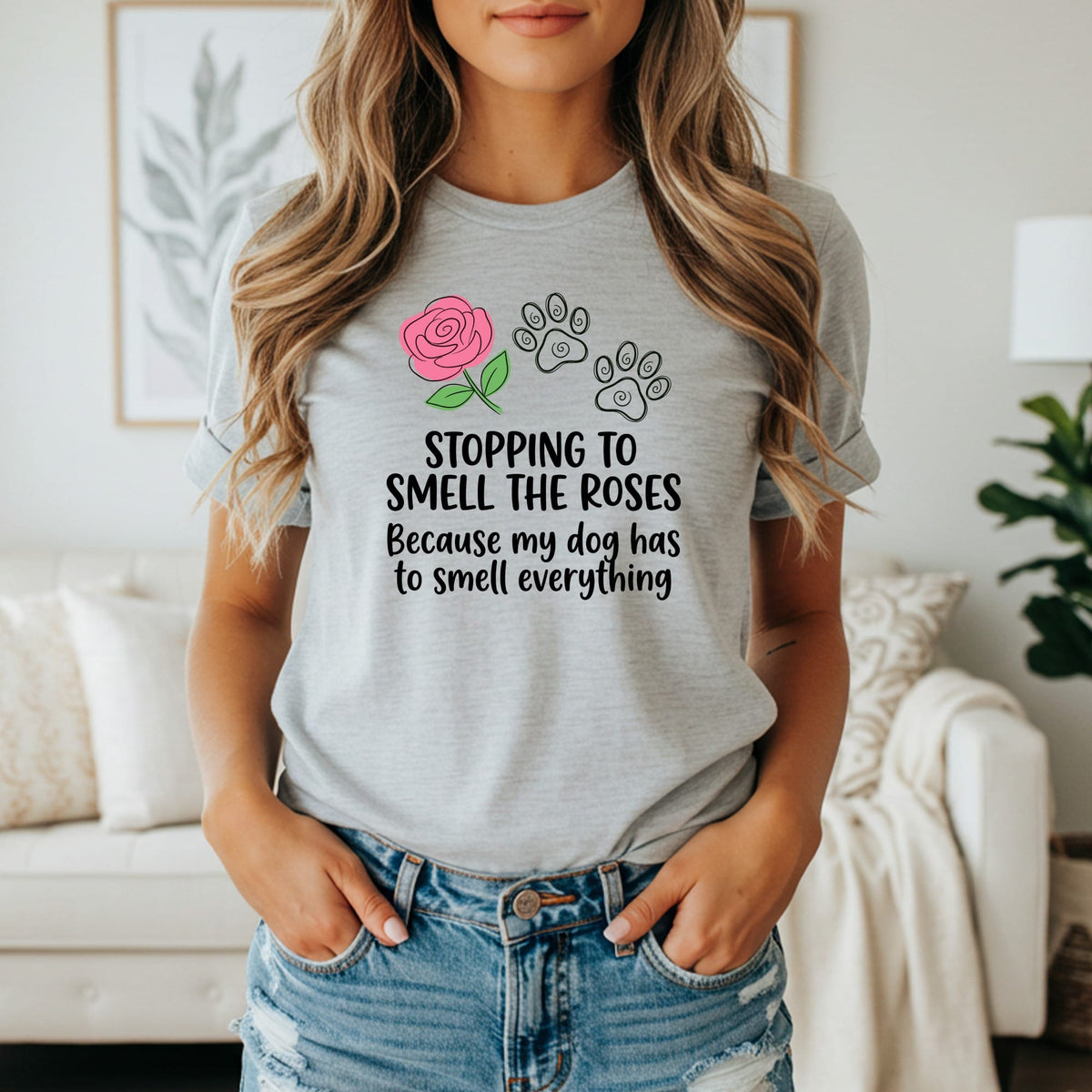 Light gray t-shirt with pink rose, paw prints, and text "Stopping to smell the roses because my dog has to smell everything."