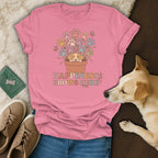 Pink t-shirt with a graphic of a puppy in a flowerpot and the text Happiness Grows Here.
