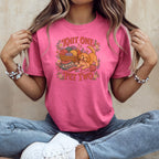 A person wearing a pink t-shirt with a graphic of a puppy, yarn, and the text Knit One Pet Two.