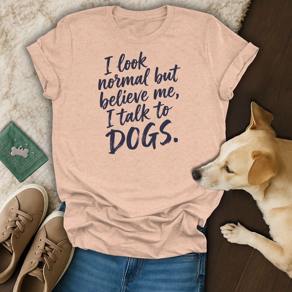 Peach t-shirt with navy text reading "I look normal but believe me, I talk to DOGS."
