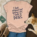 Peach t-shirt with navy text reading "I look normal but believe me, I talk to DOGS."