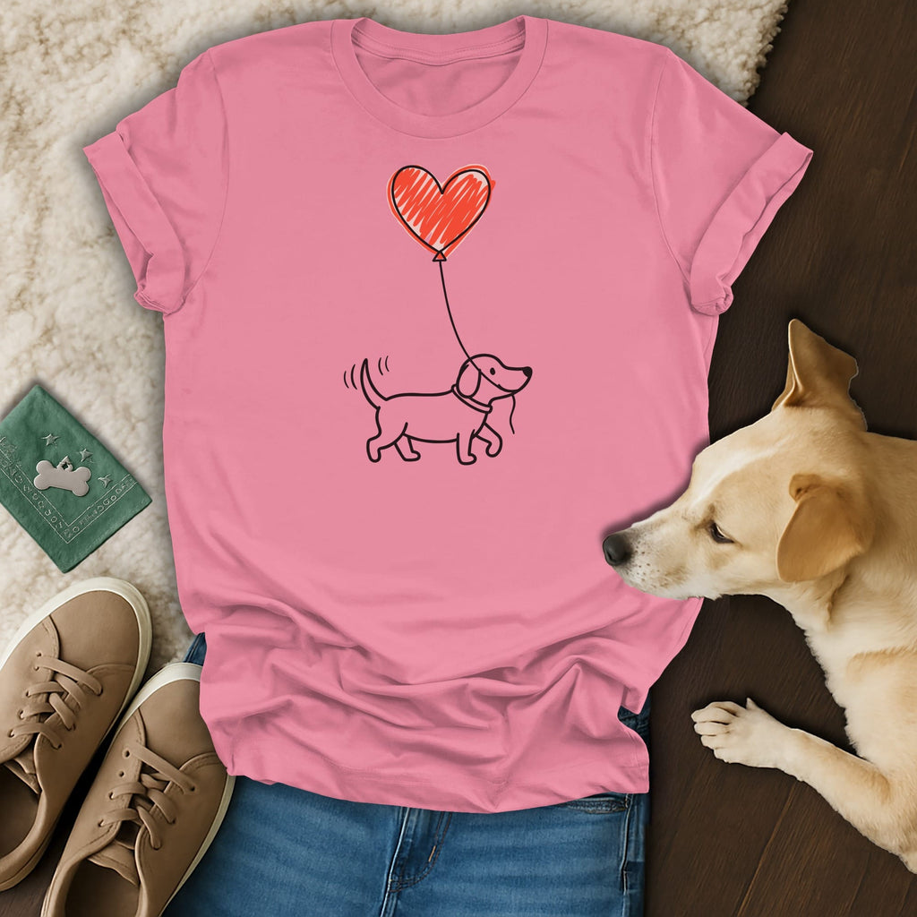 Pink t-shirt with a drawing of a dog holding a red heart balloon.