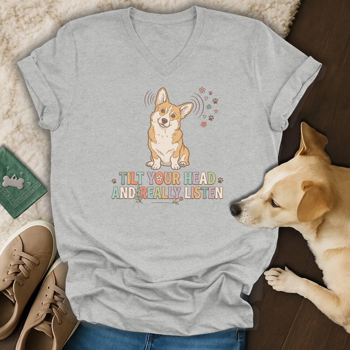 Light grey v-neck t-shirt with a corgi graphic and text "TILT YOUR HEAD AND REALLY, LISTEN".