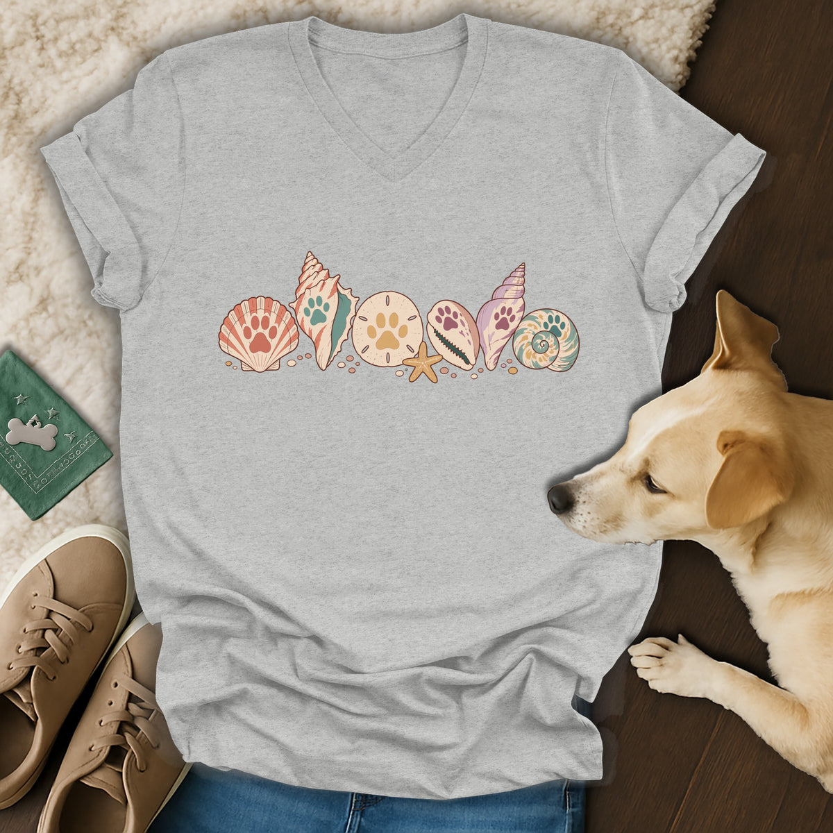 Gray v-neck t-shirt featuring a graphic of colorful seashells decorated with paw prints.