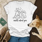 White t-shirt with line drawing of five dogs and text "mutts about you".
