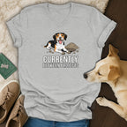 Grey t-shirt with cartoon dog and text "Currently Between Projects".
