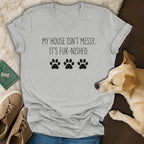 Light grey t-shirt with "My house isn't messy. It's fur-nished." and paw prints.