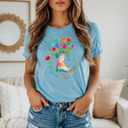 Light blue t-shirt with colorful paw prints and flowers in a boot graphic that reads "Grow Wild, Love Dogs."