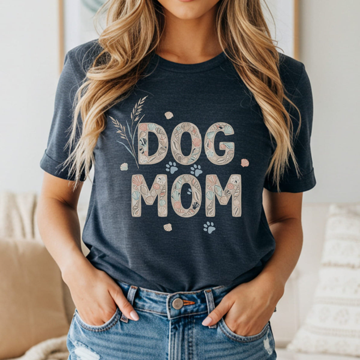 Dark t-shirt with "DOG MOM" in seashell print letters and paw prints.