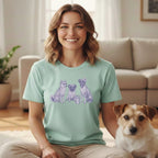 Woman wearing a t-shirt with three dogs and a plant.