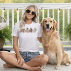 Woman wearing white t-shirt with cartoon dogs in holiday costumes and a golden retriever.