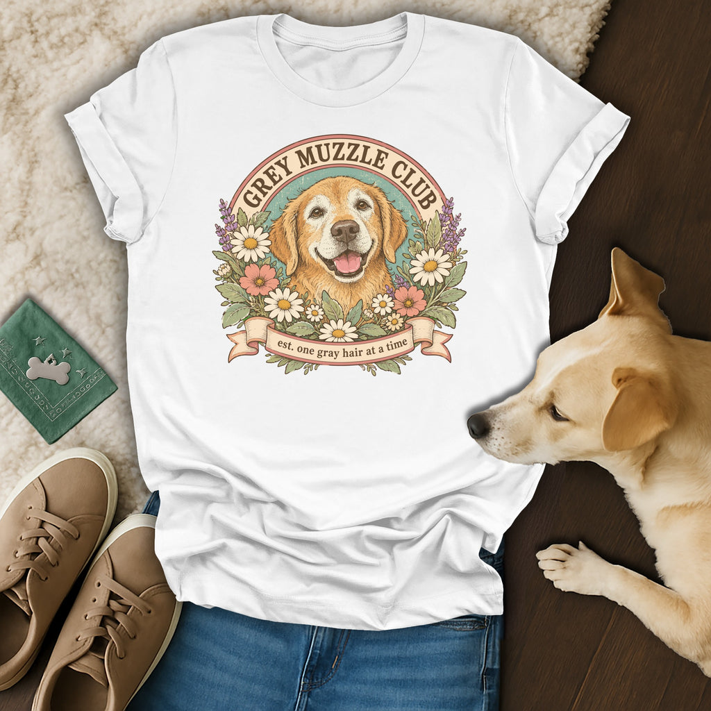 A white t-shirt featuring a retro golden retriever illustration with the text Grey Muzzle Club.
