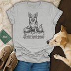 Grey t-shirt with a black and white drawing of a smiling corgi among pumpkins and text.