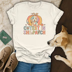 Cream t-shirt with a colorful dog in a pumpkin and text "Cutest in the Patch".