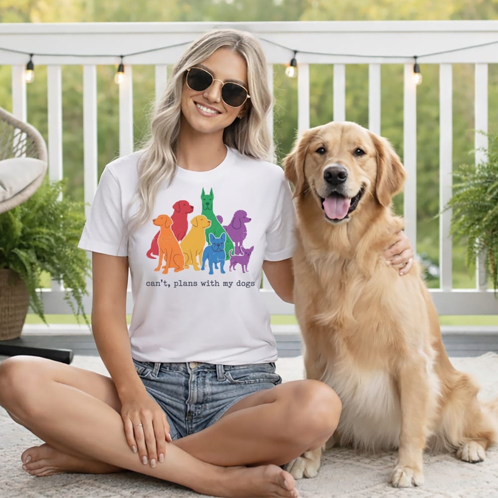 Woman in t-shirt with rainbow dogs graphic and "can't, plans with my dogs" text beside golden retriever.