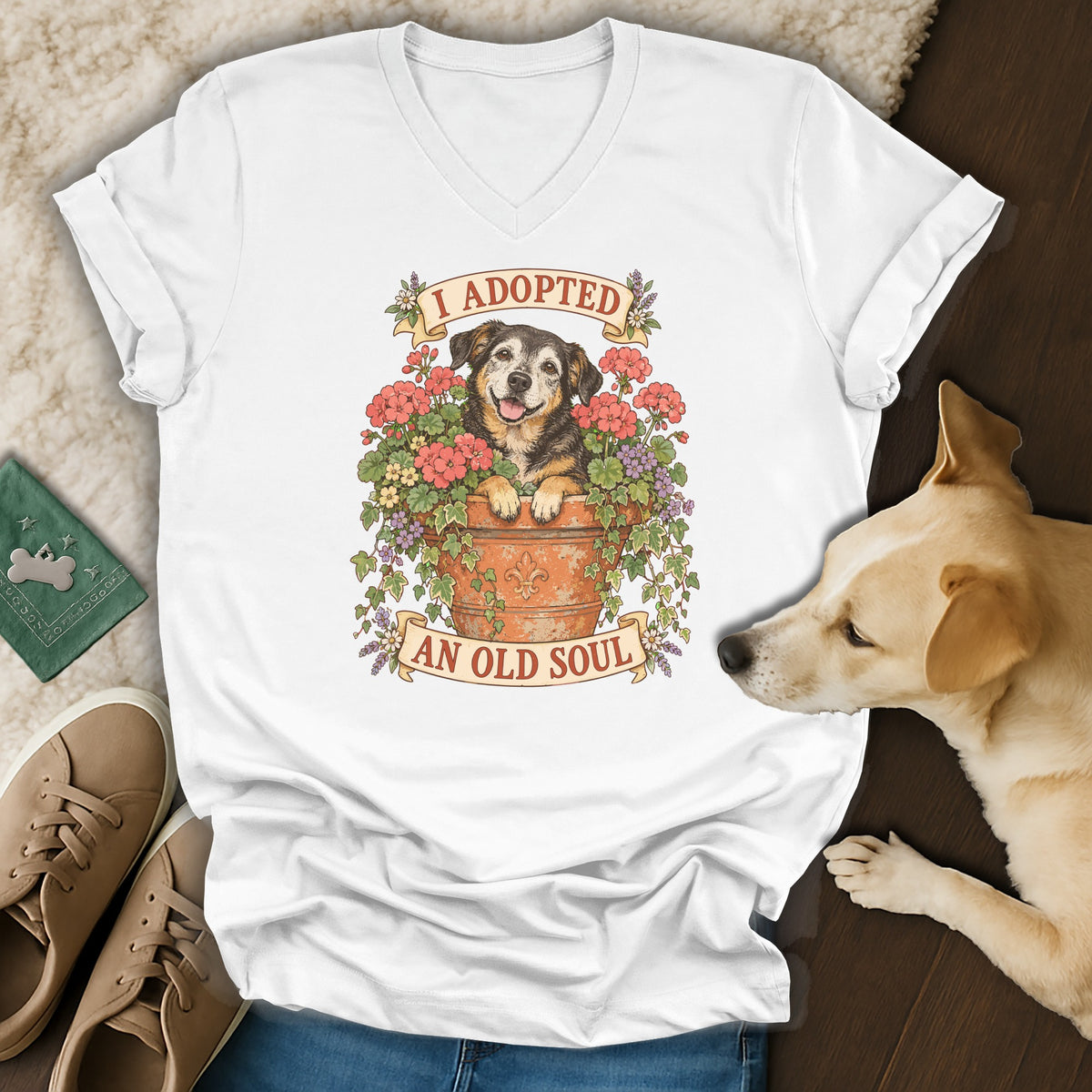 A white v-neck t-shirt featuring a graphic of a dog in a flowerpot with the text I adopted an old soul.