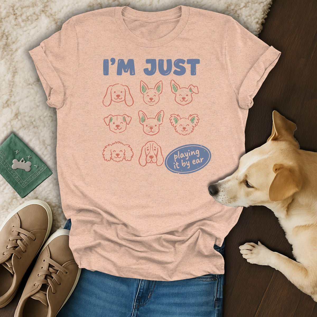 Peach t-shirt with "I'M JUST" and "playing it by ear" text and dog faces.