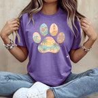Purple t-shirt with paw print design featuring beach, ocean, and lighthouse scenes.
