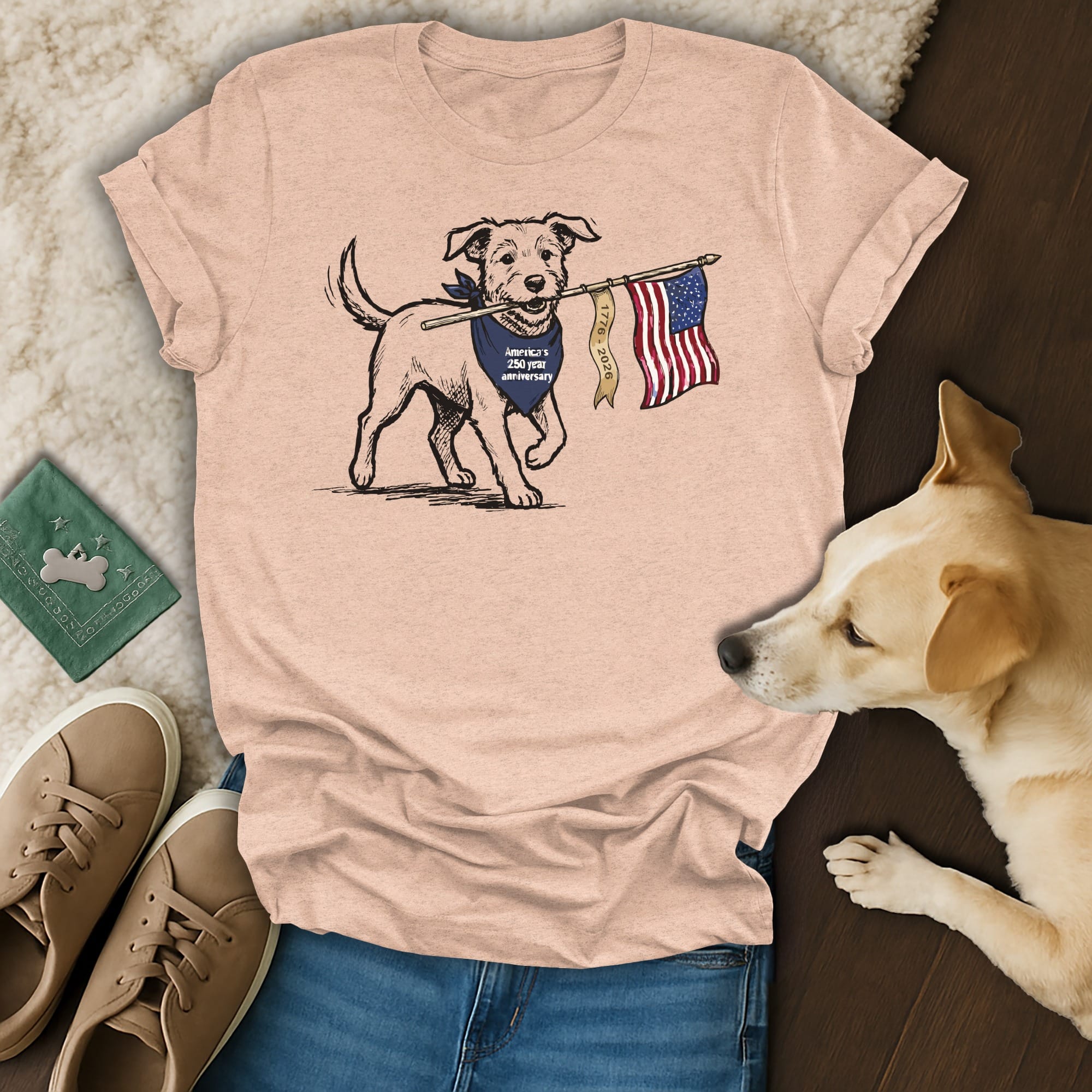 Dog wearing a bandana holds an American flag on a t-shirt.