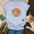 Light blue t-shirt with "Woof Stock" text, dogs in a van, and floral design.
