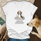 White t-shirt with a beagle sitting in ripped pillows, holding colorful ribbons, text "MINOR INCIDENT".