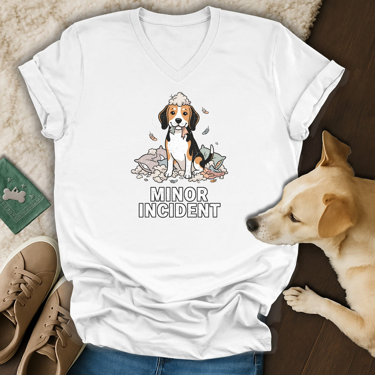 White t-shirt with a beagle sitting in ripped pillows, holding colorful ribbons, text "MINOR INCIDENT".