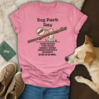 Pink t-shirt with "Dog Park Day" text and illustration of a dog carrying a large stick.