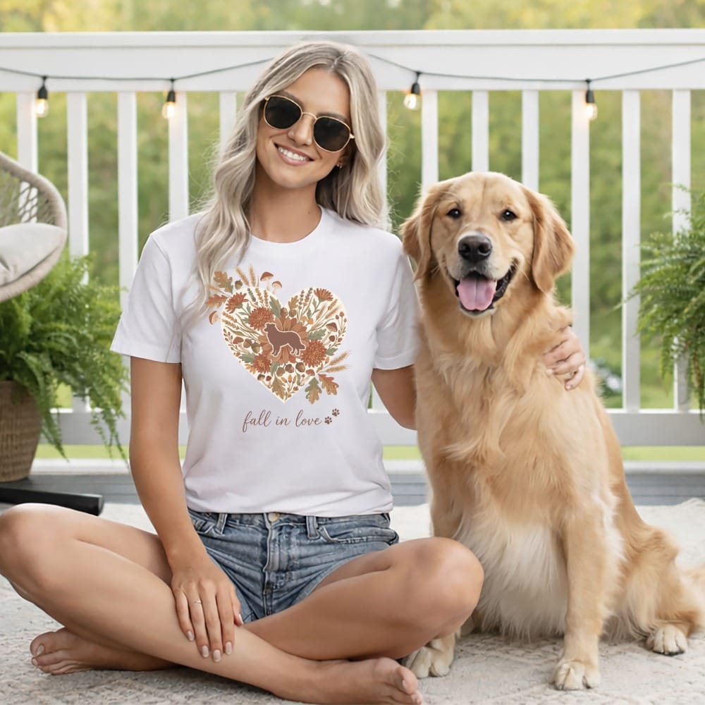 Woman and golden retriever wearing t-shirt with heart floral design that says "fall in love."