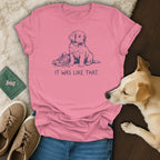 Pink t-shirt with a blue line drawing of a puppy next to a shoe and text.