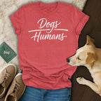 Red t-shirt with white text "Dogs Humans", dog, jeans, and sneakers.
