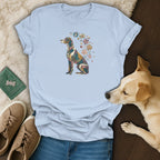 Light blue t-shirt featuring a colorful mosaic dog graphic, laid flat with jeans and accessories.