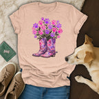 Pink floral cowboy boots with paw print flowers on a peach t-shirt.