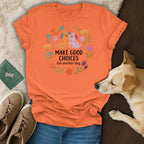 Orange t-shirt with two cartoon dogs and floral wreath, text reads "MAKE GOOD CHOICES Get another dog."