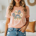 T-shirt with paw print graphic featuring camping scenes and a sleeping dog.