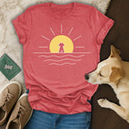 Red t-shirt with a minimalist sun and dog graphic over water.