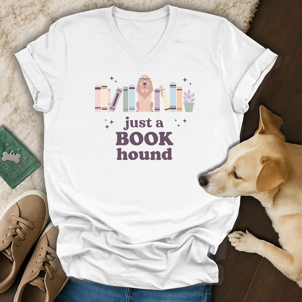 White t-shirt with "just a BOOK hound" text and illustrated dog among books.