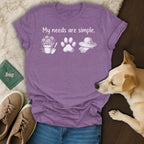 Purple t-shirt with "My needs are simple" text, flowers, paw print, and gardening hat.