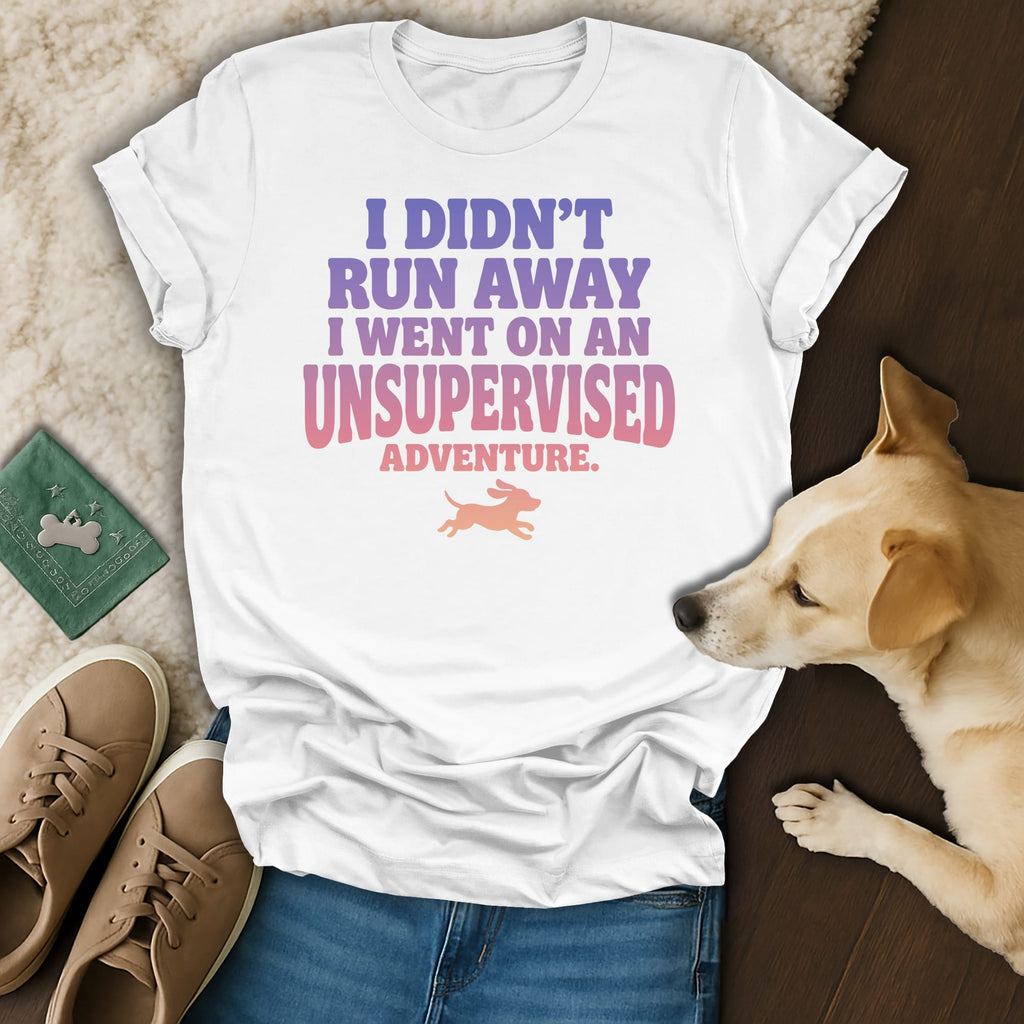 White t-shirt with pink and purple text reading "I didn't run away I went on an unsupervised adventure."